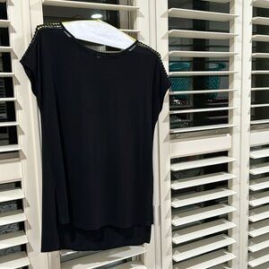 Black pullover top with decorative neck line and shoulder lines.